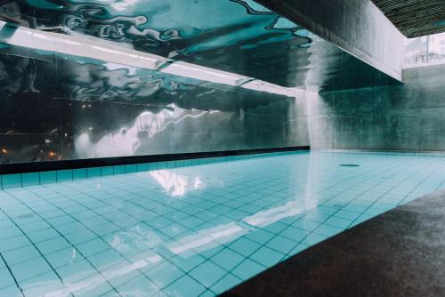 an indoor swimming pool with a water fountain at Schwarzer Adler Kitzbühel - Adults Only in Kitzbühel