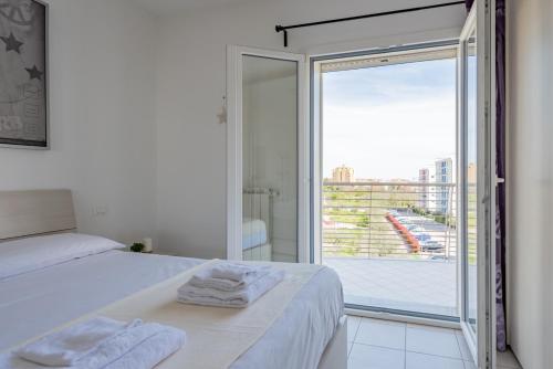 een slaapkamer met een bed en een grote glazen schuifdeur bij Spataro4 - YourPlace Abruzzo in Lanciano