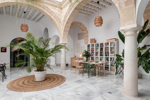 una habitación con columnas y una mesa con plantas en Art Suites by Casa de Indias, en El Puerto de Santa María