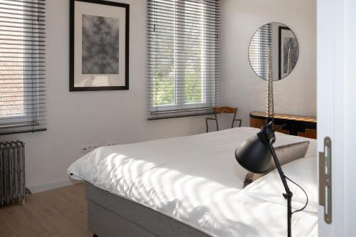 a bedroom with a bed and a mirror and windows at #MacLeod2 in Ostend
