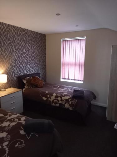 a bedroom with two beds and a window at clazzers apartment 2 in Bridlington