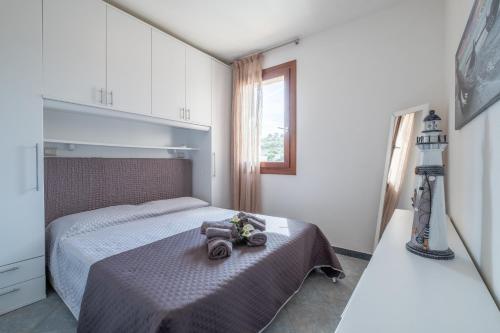 una camera da letto con un letto con una borsa sopra di CASTELSARDO- Elegante Appartamento vista Mare a Castelsardo