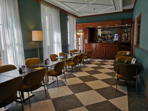 a restaurant with tables and chairs and a bar at Hotel Berna in Milan