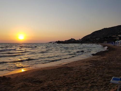 a sunset on a beach with the ocean at Appartamento Porto Marina S G 2 in Licata