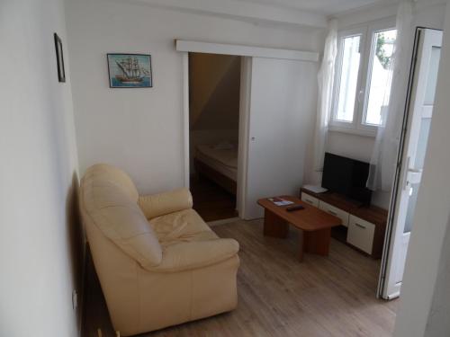 een woonkamer met een stoel en een televisie bij Apartments Only in Dubrovnik