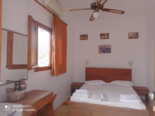 een slaapkamer met een bed en een plafondventilator bij Faragi in Agia Roumeli