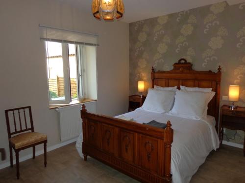 une chambre avec un lit, une chaise et une fenêtre dans l'établissement La Maison Ribotteau - The Coach House Gîte, à LʼIsle-Jourdain