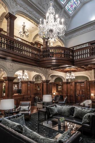 a large room with couches and a chandelier at Woodlands Park Hotel in Cobham