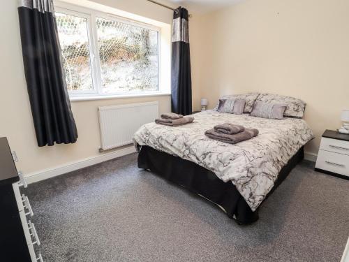 a bedroom with a bed with two towels on it at Nant House in Wrexham