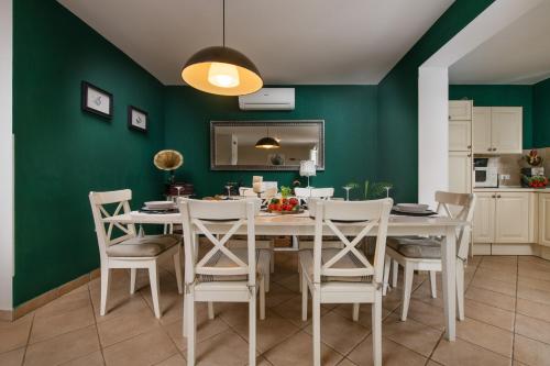 a dining room with green walls and a table and chairs at Villa Laura in Krnica