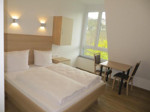 1 dormitorio con cama, mesa y ventana en Gäste- und Tagungshaus Maria Trost, en Beuron