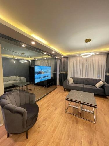 een woonkamer met banken en een flatscreen-tv bij Istanbul Suites Residance Super Lux BKY in Istanbul