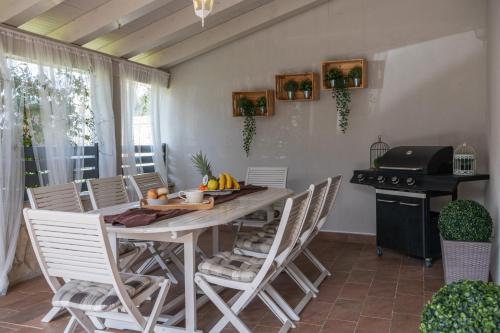 a dining room with a table and chairs and a grill at Villa Laura in Krnica