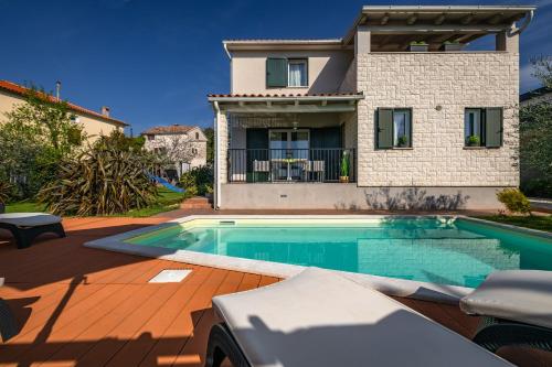 a house with a swimming pool in front of a house at Villa Laura in Krnica