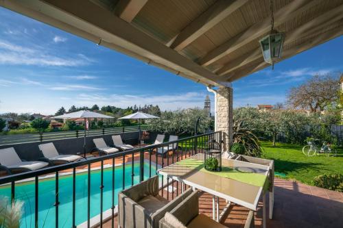 a patio with a table and chairs next to a pool at Villa Laura in Krnica