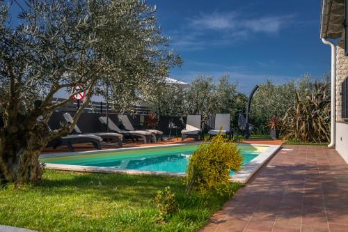 a swimming pool with lounge chairs next to a house at Villa Laura in Krnica