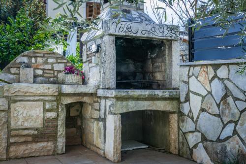 a stone fireplace in a yard with a stone wall at Villa Laura in Krnica
