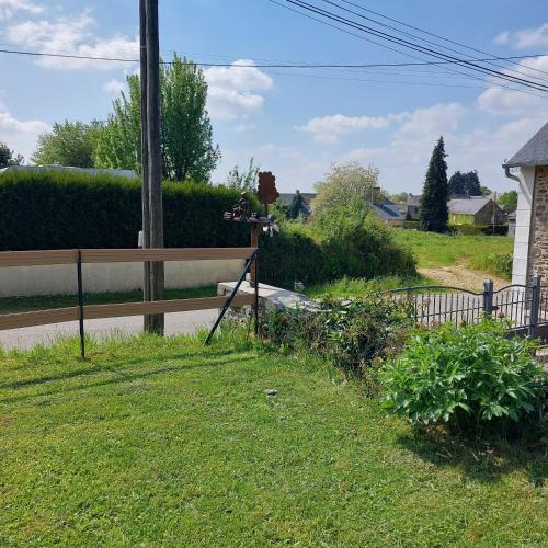 a yard with a fence on the side of a road at La lavandiere in La Chapelle-au-Riboul