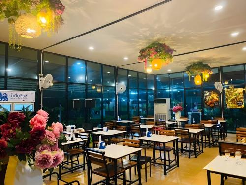 a restaurant with tables and chairs and flowers at Trang Villa Hotel and Water Park in Trang