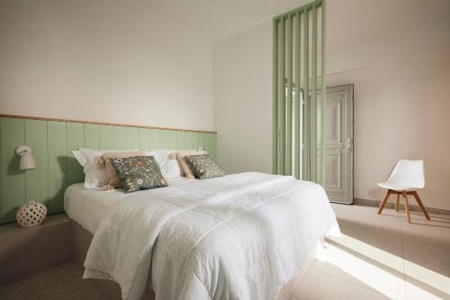 a bedroom with a bed with white sheets and pillows at Kanala Studios in Kithnos