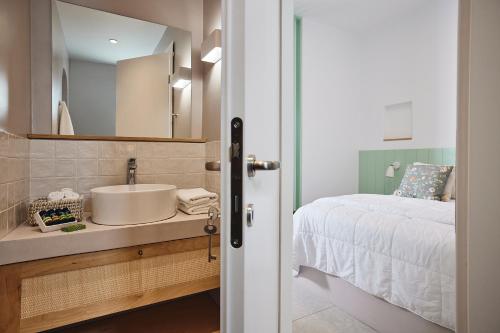 a bathroom with a sink and a bed at Kanala Studios in Kithnos