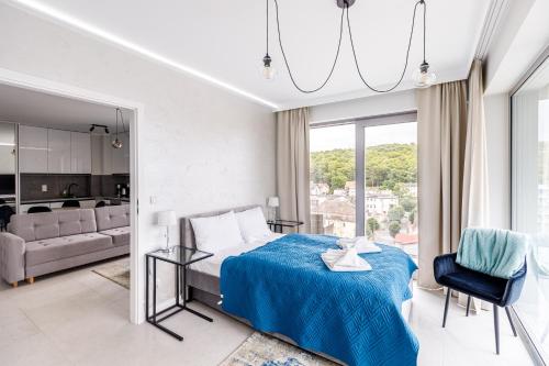a bedroom with a bed and a living room at Balticus Apartamenty Promenada Gwiazd 14 in Międzyzdroje