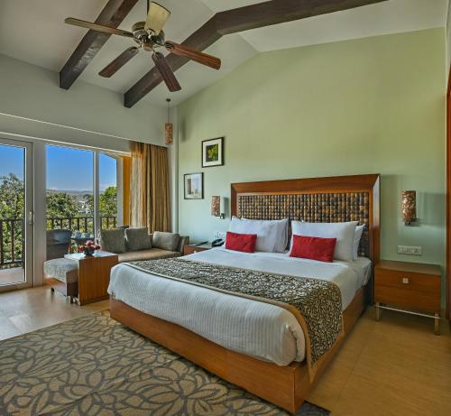 a bedroom with a large bed and a living room at Fariyas Resort Lonavala in Lonavala