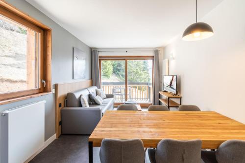 a living room with a table and a couch at Vacancéole - Les Ecrins d'Auris in Auris