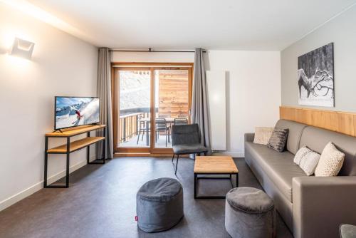 a living room with a couch and a table at Vacancéole - Les Ecrins d'Auris in Auris
