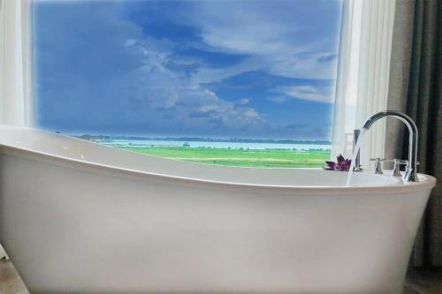 a bath tub with a window with a view of the ocean at Blue Wild - Yala - Plastic Free & Sustainable in Tissamaharama