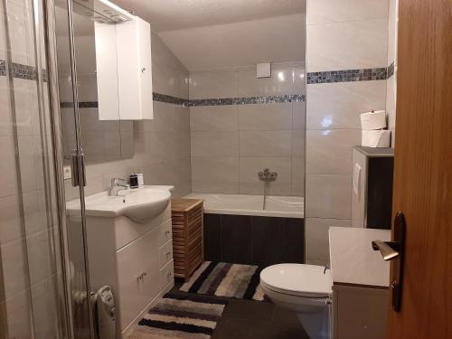 ein Badezimmer mit einem Waschbecken, einem WC und einer Badewanne in der Unterkunft Ferienwohnung Kuenzer Alm in Matrei in Osttirol