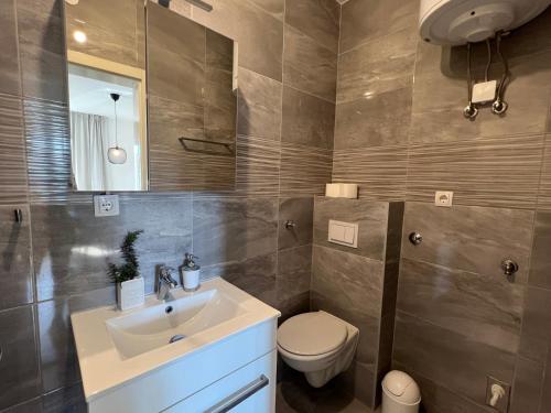 W łazience znajduje się umywalka, toaleta i lustro. w obiekcie The ONE By Moro w mieście Vantačići