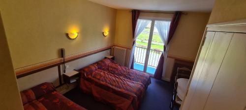 een woonkamer met een bank en een raam bij Le VAL du CANTAL in Polminhac