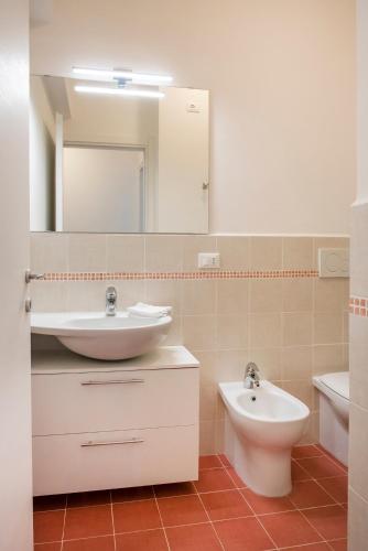 a bathroom with a sink and a toilet and a mirror at A casa di Marica in Sirolo