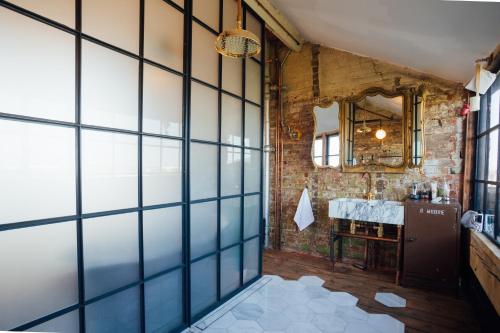 a bathroom with a brick wall and a mirror at Destinesia Jason Works in Loughborough