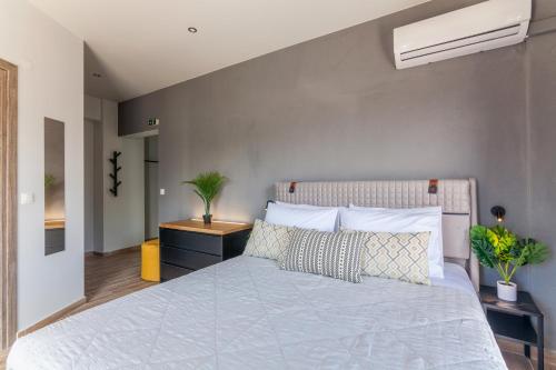 a bedroom with a large bed with white sheets and pillows at Raise Kornarou City Stay in Heraklio Town