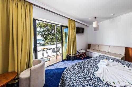 Un pat sau paturi într-o cameră la Hotel Ilirija