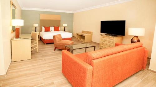 a hotel room with a bed and a living room at Mövenpick Resort Petra in Wadi Musa