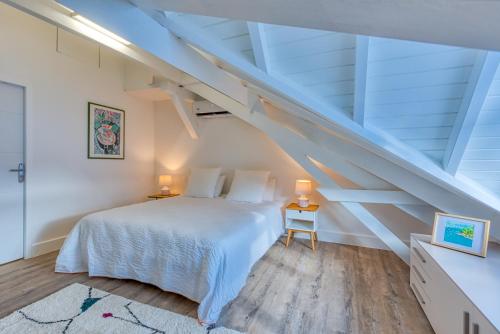 a bedroom with a white bed and a staircase at One bedroom loft marina Anse Marcel in Cul de Sac