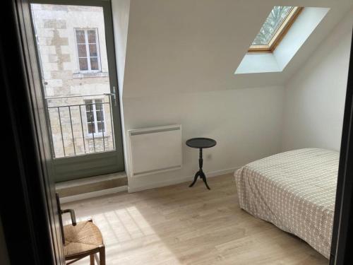 um quarto com uma cama e uma janela em Le Gîte de Moquesouris em Nazelles