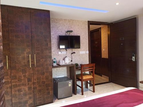 a room with a bed and a desk and a chair at Hotel A P Home's - A Boutique Hotel in Guwahati