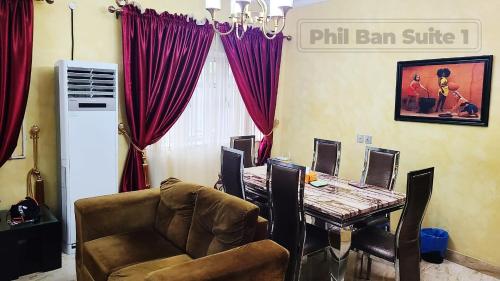 a dining room with a table and a chair at PhilBan Suites 1 in Ikeja