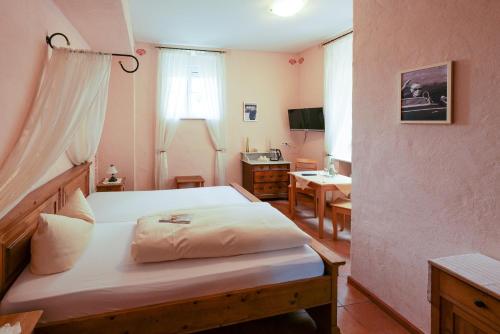 a bedroom with a bed and a desk in it at Alte Bürgermeisterei in Ediger-Eller