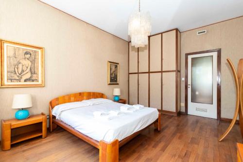a bedroom with a bed and a table with a lamp at Massaua Roomy Vintage Apartment in Turin
