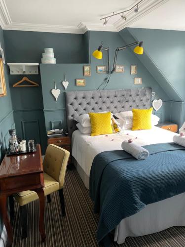 a hotel room with a bed, desk, chair, and lamp at Albyn Townhouse in Edinburgh