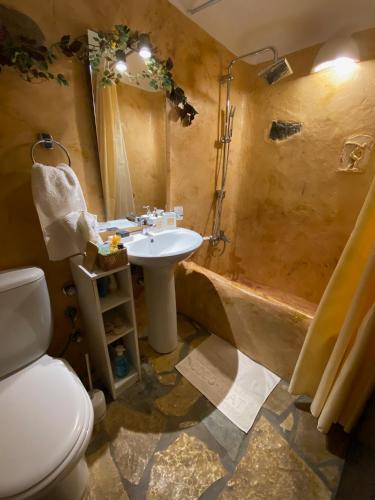 a bathroom with a sink and a toilet and a tub at Wood & Stone - Paros in Aspro Chorio Paros