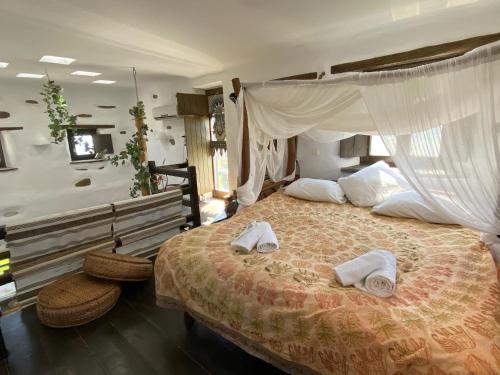 a bedroom with a large bed with towels on it at Wood & Stone - Paros in Aspro Chorio Paros