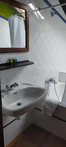 a bathroom with a white sink and a mirror at Hostal Mendaurpe in Ituren