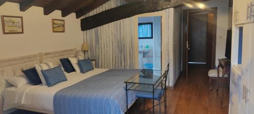 Hostal Mendaurpe في Ituren: غرفة نوم بسرير كبير مع طاولة زجاجية