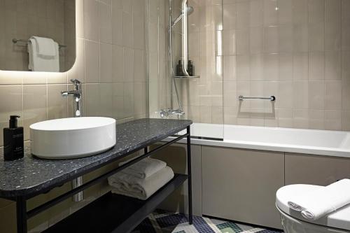 une salle de bain avec un lavabo et une baignoire dans l'établissement Solo Sokos Hotel Torni Helsinki, à Helsinki